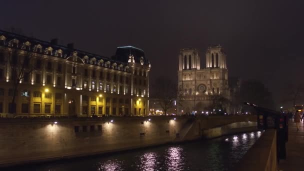 A fachada ocidental da famosa catedral de Notre Dame de Paris iluminada à noite. Destino turístico popular. Vídeo 4K — Vídeo de Stock