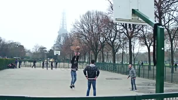 Paris, Francja - 31 grudnia 2016 roku. Steadicam strzał multinatonal nastolatków gra Koszykówka uliczna przeciwko Wieża Eiffla na mgliste dni. 4 k wideo — Wideo stockowe