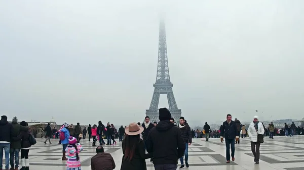 Paris, Frankrike -, 31 December 2016. Multinatonal turister gör bilder och selfies nära Eiffeltornet på en dimmig dag. De mest populära franska landmark, turistiska intressepunkter — Stockfoto