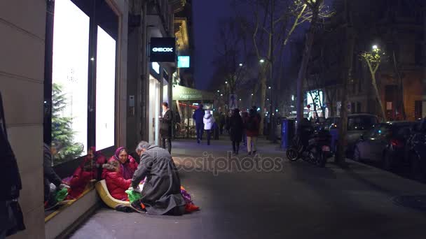 PARIS, FRANÇA - DEZEMBRO, 31 de dezembro de 2016. Um homem local a dar presentes a uma menina imigrante sentada na rua. Tolerância à imigração e bondade. Vídeo 4K — Vídeo de Stock