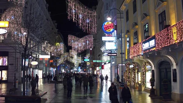 VIENNE, AUTRICHE - 24 DÉCEMBRE 2016. Noël décoré rue piétonne dans la soirée. Endroit touristique populaire avec beaucoup de magasins et cafés — Photo