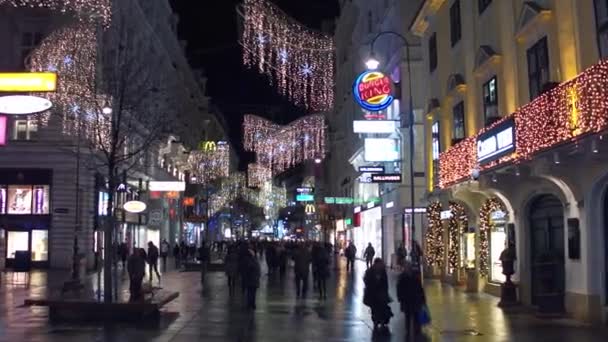 VIENA, ÁUSTRIA - DEZEMBRO, 24, 2016. Steadicam tiro de Natal rua pedestre decorada à noite. Lugar turístico popular com abundância de lojas e cafés. Clipe 4K — Vídeo de Stock