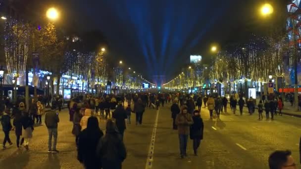 Paříž, Francie - 31 prosinec 2016. Steadicam procházka po přeplněných zdobené Champs-Elysees ulice směrem k slavný vítězný oblouk, Arc de Triomphe. Nový rok večer. 4 k klip — Stock video