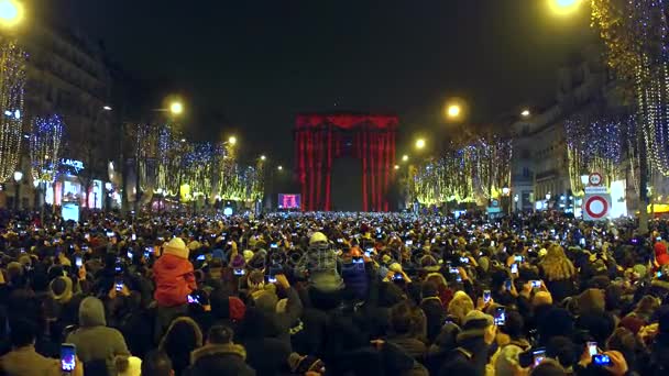 Paris, Frankreich - 31. Dezember 2016. Überkopfschuss der belebten Champs-Élysées Straße und Lichtshow auf dem berühmten Triumphbogen, Arc de triomphe. Silvester. 4k-Video — Stockvideo