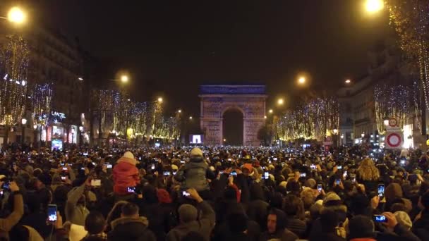 パリ, フランス - 2016 年 12 月 31 日。混雑のシャンゼリゼ通りと有名な凱旋門、凱旋門の光のショーのオーバー ヘッド ショット。大晦日。4 k クリップ — ストック動画