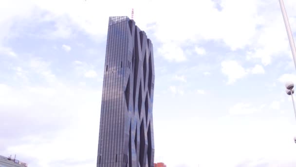 ВЕНА, Австрия - ДЕКАБРЬ, 24 Steadicam снимок Донау Сити Тауэр, отражающий облака и голубое небо. Современное офисное здание в Вене, Австрия. 4K видео — стоковое видео