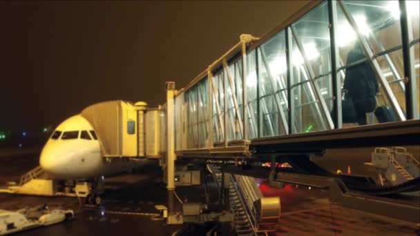 Nie do poznania pasażerów na pokład samolotu przy użyciu szkła strumieniem most nocą. Podróży, wyjazd, pozostawiając pojęć. wideo 4k — Wideo stockowe