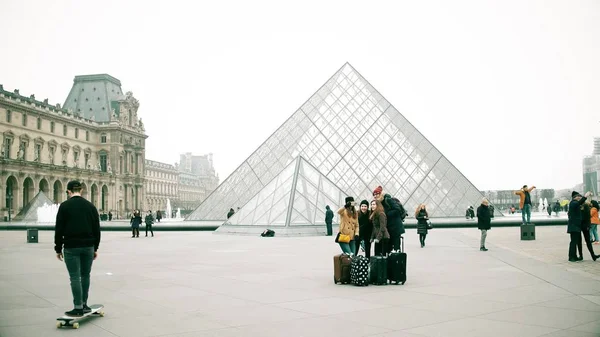 PARÍS, FRANCIA - 31 DE DICIEMBRE DE 2016. Jóvenes haciendo selfie cerca del Louvre, famoso museo francés y popular destino turístico — Foto de Stock