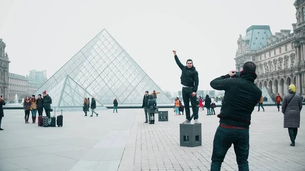 Paris, france - dezember, 31, 2016. touristen posieren und machen fotos in der nähe des rasters, berühmtes französisches museum. Beliebtes Touristenziel — Stockfoto