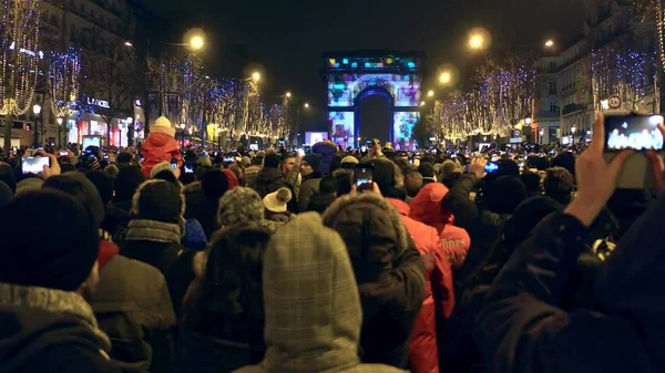 PARIS, FRANÇA - DEZEMBRO, 31 de dezembro de 2016. Crowded Champs-Elysees rua e show de luz no famoso arco triunfal, Arco do Triunfo. Véspera de Ano Novo — Fotografia de Stock