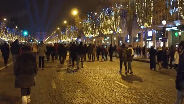 Paris, Fransa - Aralık, 31, 2016. Champs-Elysees caddesi ve ünlü zafer takı Arc de Triomphe kalabalık. Yeni yıl arifesinde. 4k video — Stok video