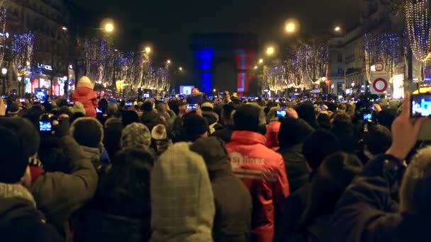 PARÍS, FRANCIA - 31 DE DICIEMBRE DE 2016. Crowded Champs-Elysees street and light show on famous triumphal arch, Arc de Triomphe. Nochevieja. Vídeo 4K — Vídeo de stock