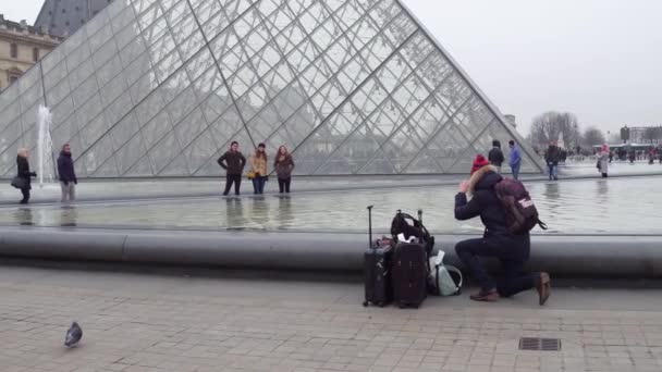 PARÍS, FRANCIA - 31 DE DICIEMBRE DE 2016. Steadicam foto de turistas posando y haciendo fotos cerca del Louvre, famoso museo francés y popular destino turístico. Vídeo 4K — Vídeos de Stock