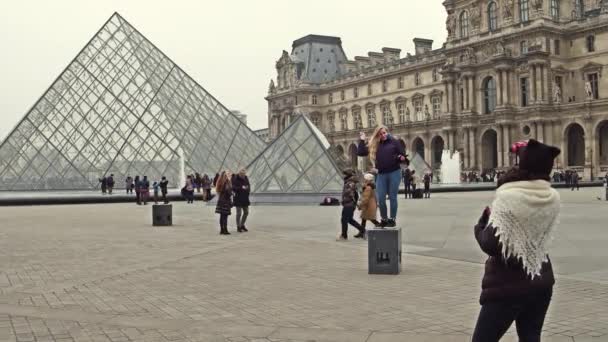 Paris, Frankrijk - 31 December 2016. Vrouwelijke toeristen poseren en het maken van foto's in de buurt van het Louvre, de beroemde Franse museum en de populaire toeristische bestemming. 4k video — Stockvideo