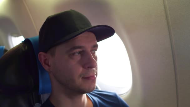 Doordachte Kaukasische man reist op vliegtuig. 4 k close-up shot — Stockvideo