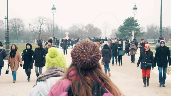 PARIS, FRANCE - DECEMBER, 31, 2016. Multinatonal tourists walk near Ferris wheel on a foggy day. Popular Parisian landmark and touristic destination — ストック写真