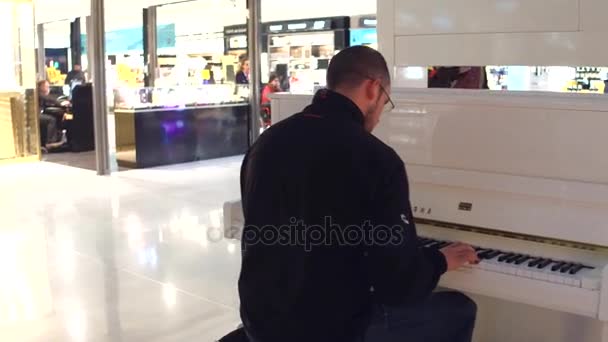 파리, 프랑스-1 월 1, 2017 Steadicam 남자가 공항에 면세점 매장 영역에 피아노 연주를 쐈 어. 4 k 비디오 — 비디오