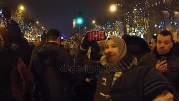 ПАРИЖ, ФРАНЦИЯ - 31 ДЕКАБРЯ 2016 года. Мусульманская женщина записывает панорамное видео улицы Елисейских полей накануне Нового года. 4K видео — стоковое видео