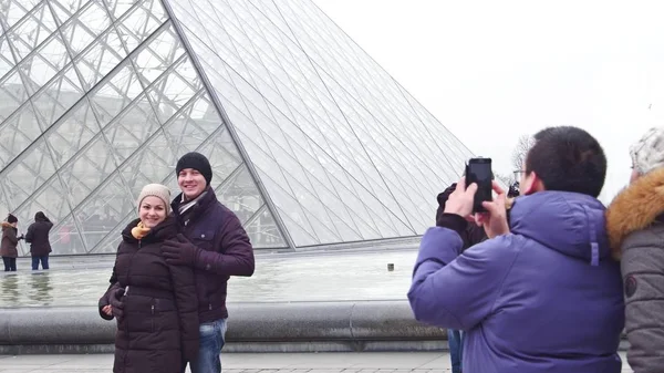 Paris, Frankreich - 31. Dezember 2016. Glückliches Paar posiert in der Nähe des Louvre, dem berühmten französischen Museum und beliebten Touristenziel — Stockfoto