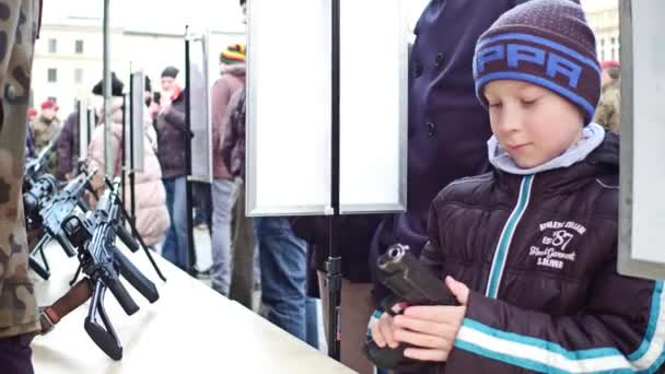 KRAKOW, POLAND - JANUARY, 14, 2017 Army officer demonstrates pistol to a boy. WOSP military show. 4K video — Stock Video