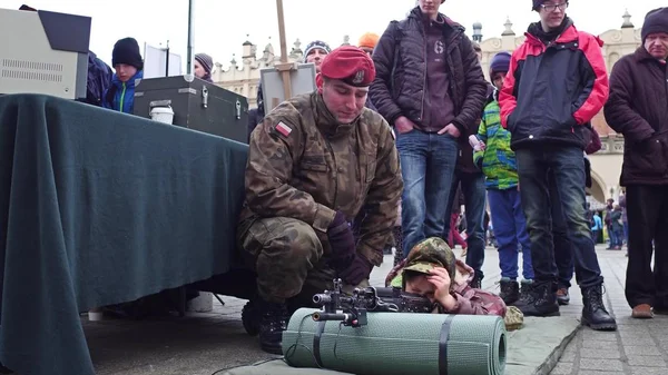 Krakau, Polen - 14. Januar 2017: Ein polnischer Armeeoffizier demonstriert einem kleinen Jungen das Sturmgewehr. wosp Militärshow — Stockfoto