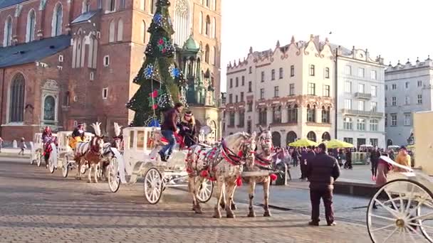 KRAKOW, POLONIA - 14 DE ENERO DE 2017 Steadicam tiro de caballos retro carruajes tirados y la Navidad decorada turística de la Ciudad Vieja de la calle. Vídeo 4K — Vídeos de Stock
