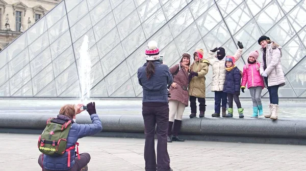 パリ, フランス - 2016 年 12 月 31 日。ポーズの陽気な家族とルーブル近く、有名なフランスの美術館、人気のある観光地の写真を作る — ストック写真