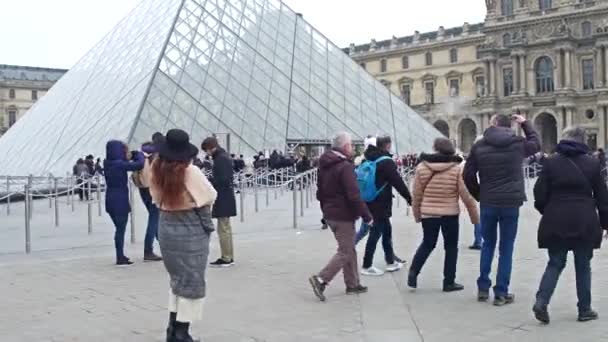 PARÍS, FRANCIA - 31 DE DICIEMBRE DE 2016. Steadicam plano de plaza llena de gente cerca de la entrada del Louvre, famoso museo francés y destino turístico popular. Vídeo 4K — Vídeos de Stock