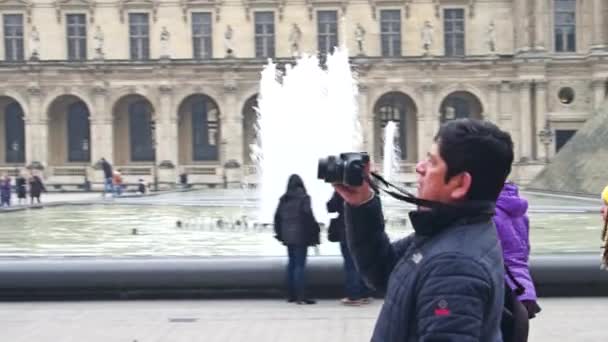 Париж, Франція - 31 грудня 2016. Чоловічий туристичних зйомки портативний відео з його камерою, поблизу Лувру, знаменитий французький музей. Популярні туристичні місця призначення. 4 к відео — стокове відео