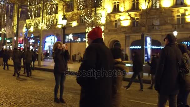 Paris, Fransa - Aralık, 31, 2016. İnsanların fotoğrafları akşamları kalabalık Champs-Elysees caddesi üzerinde yapma. Yeni yıl arifesinde. 4k video — Stok video