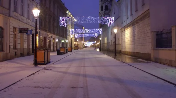 KRAKOW, PUOLA - Tammikuu, 14, 2017 Valaistu vanha kaupunki tyhjä katu lumessa — kuvapankkivalokuva