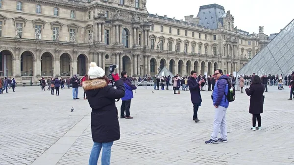 Paříž, Francie - 31 prosinec 2016. Turisté, pózování a fotí v blízkosti Louvru, slavné francouzské muzeum populární turistické destinace — Stock fotografie