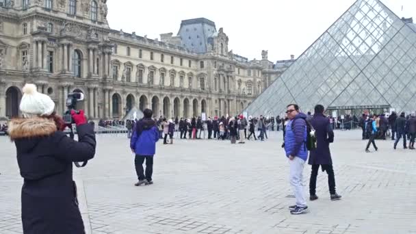 Paris, Frankreich - 31. Dezember 2016. Touristen posieren und fotografieren in der Nähe des Louvre, des berühmten französischen Museums und beliebten Touristenziels. 4k-Clip — Stockvideo