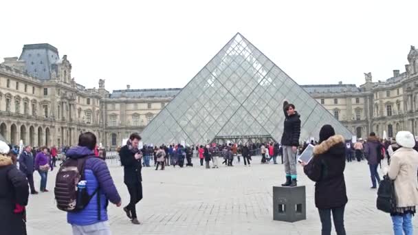 PARÍS, FRANCIA - 31 DE DICIEMBRE DE 2016. Turista posando y tomando fotos cerca de la pirámide del Louvre. Vídeo 4K — Vídeos de Stock