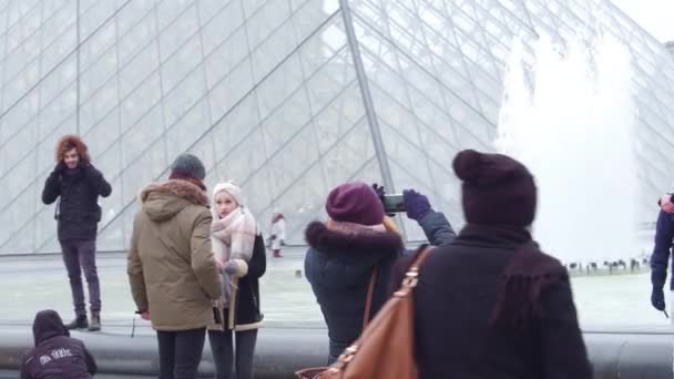 ПАРИЖ, ФРАНЦИЯ - 31 ДЕКАБРЯ 2016 года. Турист позирует и фотографирует рядом с Лувром, знаменитым французским музеем и туристическим центром. 4K видео — стоковое видео