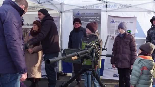 KRAKOW, POLONIA - GENNAIO, 14, 2017 I ragazzini esaminano le mitragliatrici pesanti allo spettacolo militare WOSP. Video 4K — Video Stock