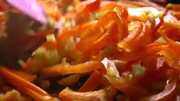 Смешивание срезанных овощей в сковороде. Жареный сладкий перец и сельдерей. 4К крупным планом — стоковое видео