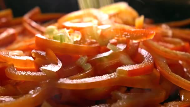 Acrescentar o aipo verde para cortar o pimentão doce em uma panela de ato de fritar. Vídeo de close-up 4K — Vídeo de Stock