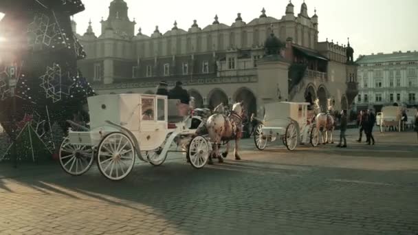 Kraków, Polska - 14 stycznia 2017 Steadicam strzał z retro bryczkami i Boże Narodzenie urządzone uliczkę starego miasta. 4 k wideo — Wideo stockowe