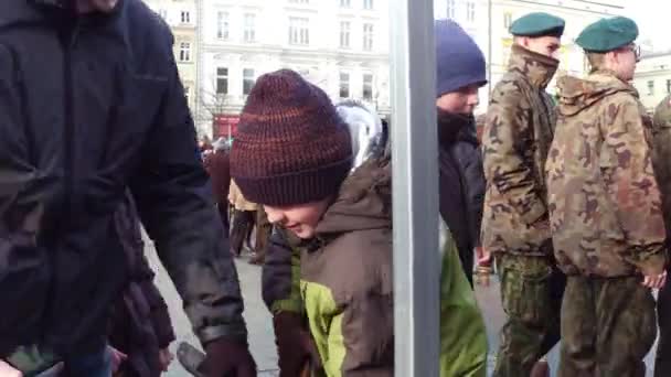 KRAKOW, POLONIA - 14 de enero de 2017 Niño pequeño toma rifle de francotirador en el espectáculo militar. Vídeo 4K — Vídeo de stock