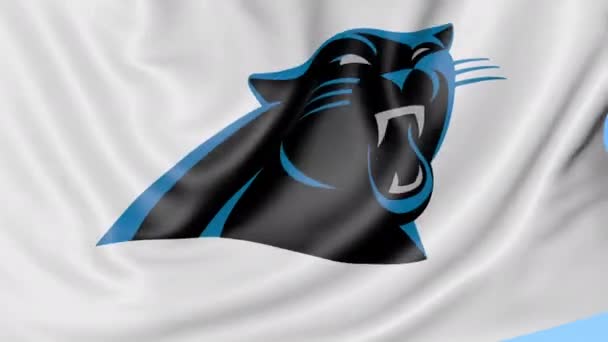 Gros plan du drapeau ondulé avec le logo de l'équipe de football américaine Carolina Panthers NFL, boucle transparente, fond bleu. Animation éditoriale. 4K — Video