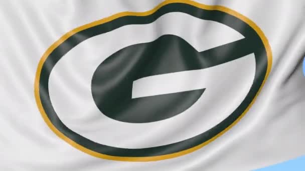 Primer plano de la bandera ondeante con el logotipo del equipo de fútbol americano Green Bay Packers NFL, bucle sin costuras, fondo azul. Animación editorial. 4K — Vídeos de Stock