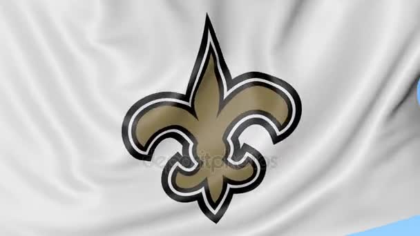 Gros plan du drapeau ondulé avec le logo de l'équipe américaine de football de la Nouvelle-Orléans Saints NFL, boucle transparente, fond bleu. Animation éditoriale. 4K — Video