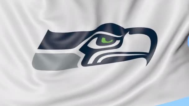 Close-up dari melambaikan bendera dengan Seattle Seahawks NFL Amerika tim sepak bola logo, loop mulus, latar belakang biru. Animasi editorial. 4K — Stok Video