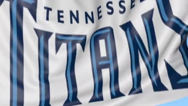 Primo piano della bandiera sventolante con il logo della squadra di football americano dei Tennessee Titans NFL, anello senza cuciture, sfondo blu. Animazione editoriale. 4K — Video Stock