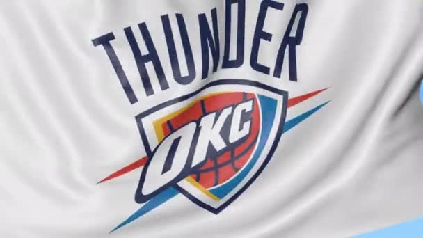 Detail mávat vlajkou s logo týmu basketbalové Nba Oklahoma City Thunder, bezešvé smyčka, modré pozadí. Redakční animace. 4k — Stock video