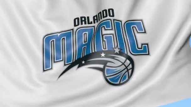 Gros plan du drapeau ondulé avec le logo de l'équipe de basket-ball Orlando Magic NBA, boucle transparente, fond bleu. Animation éditoriale. 4K — Video