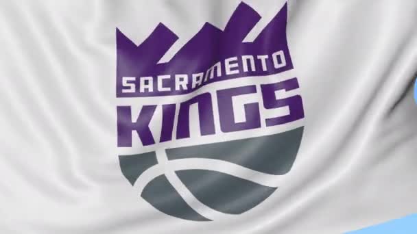 Primer plano de la bandera ondeando con Sacramento Kings logotipo del equipo de baloncesto de la NBA, bucle sin costuras, fondo azul. Animación editorial. 4K — Vídeos de Stock