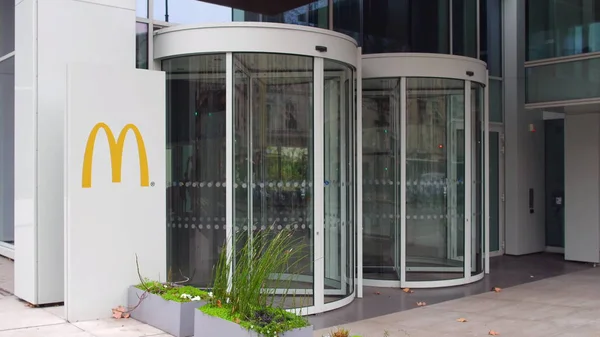 Straat signalisatie bord met Mcdonalds logo. Modern kantoorgebouw. Redactioneel 3D-rendering — Stockfoto