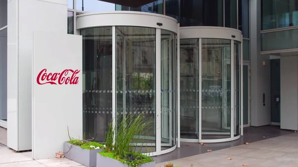 Straat signalisatie bord met Coca-Cola logo. Modern kantoorgebouw. Redactioneel 3D-rendering — Stockfoto